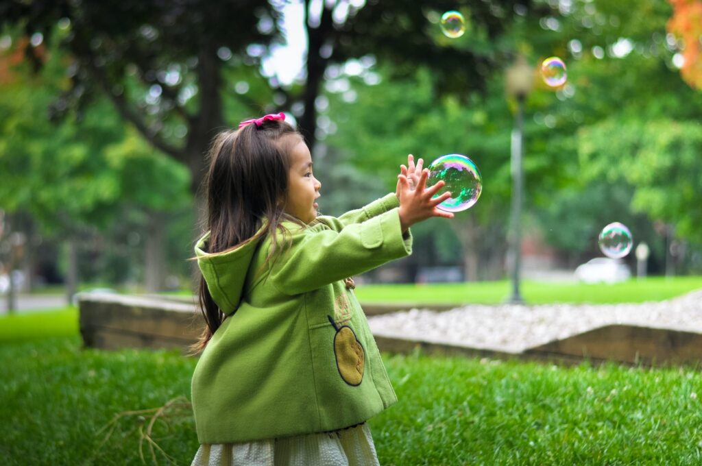 young girl chasing a bubble