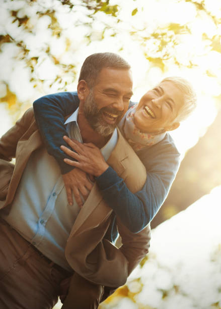 Closeup front view of a mature couple having fun in the park on a sunny day.
